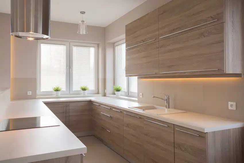 Kitchen with solid surface countertops, white windows and chrome faucet