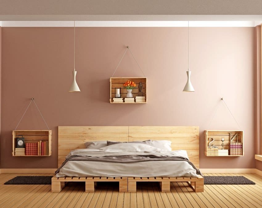 Modern minimalist bedroom with brown wall paint, pallet bed and wooden crates used as nightstands