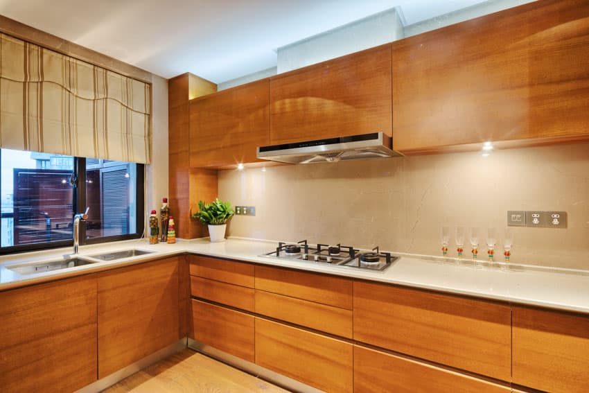 Modern wood kitchen with refaced cabinets, countertop, stove, range hood, sink, faucet, window, and curtains