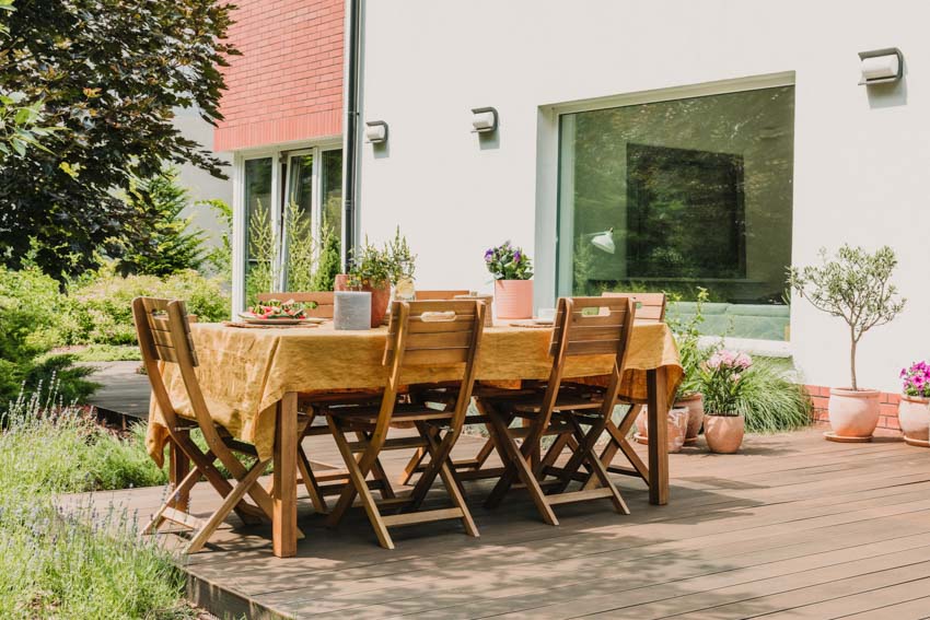 Outdoor patio with elm wood table, chairs, wood deck, and plants