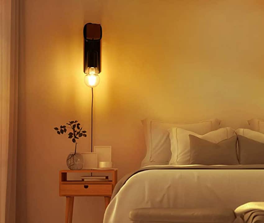 Plug-in wall sconce for bedrooms with nightstand and pillows