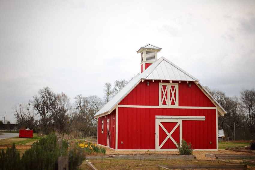Pole barn with white and red color schemes, barn door, and chimney