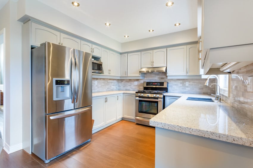 Kitchen with granite countertops, steel appliances and recessed lighting