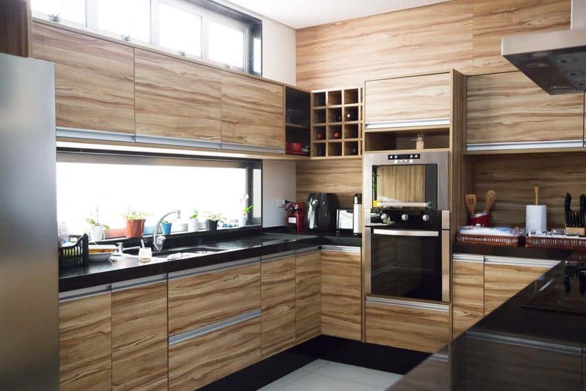 Kitchen with Wood laminate cabinets, black countertop and wooden backsplash