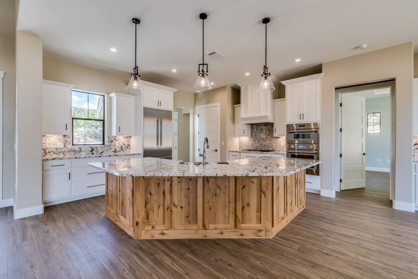 Rustic kitchen with cypress cabinets installed on the island, white cabinets, countertop, pendant lights, window, and wood flooring