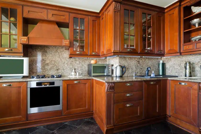 Kitchen with cabinets, oven, stove, granite backsplash, and tile floors