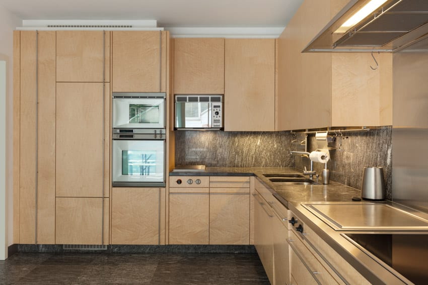 Rustic kitchen with oven granite backsplash, countertop, and pressed wood cabinets