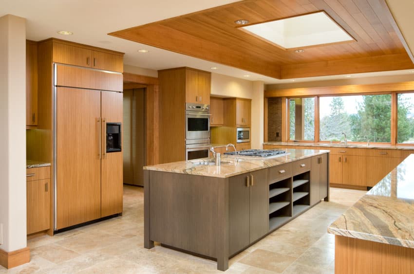 Rustic kitchen with wood cabinets, windows, oven, and skylight window