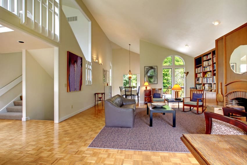 Room with Wright style furniture, rocking chairs, couch, rug, bookshelf and fireplace