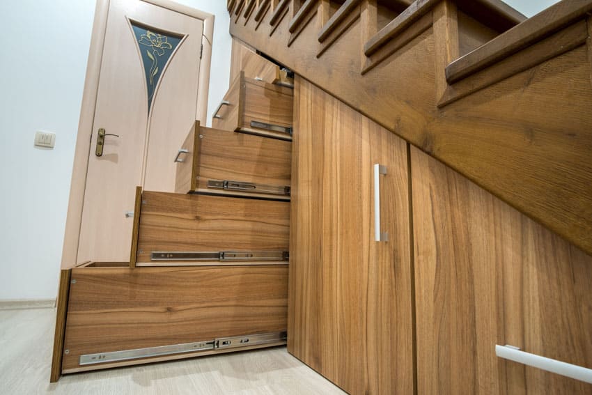 Staircase made of wood with cabinet doors drawers and slides