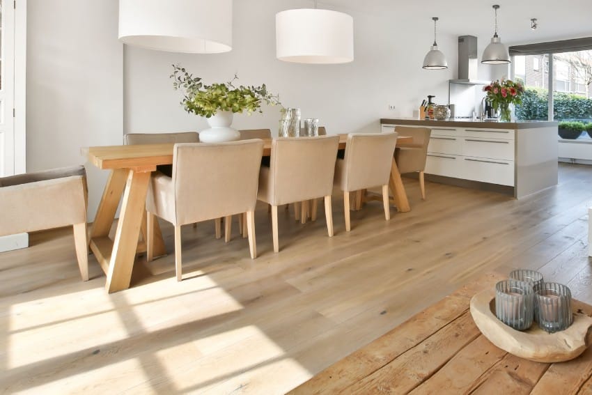 Studio format interior with engineered wood floors and manufactured wood furniture in dining area with a small kitchen
