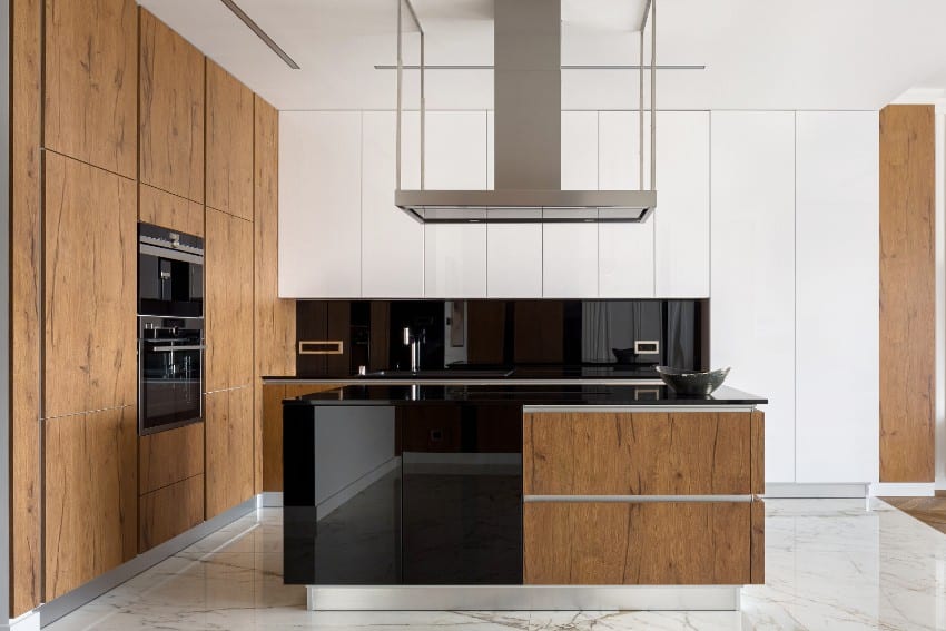 Stylish kitchen features cabinets with polyurethane protective wood finish, island and marble floor tiles