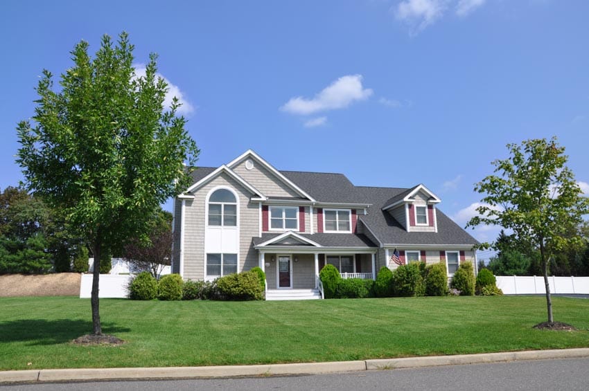 Suburban type house with front porch, windows, and dormer