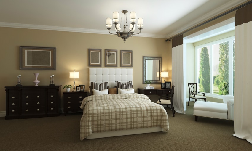 Transitional bedroom with two different dressers side by side, chandelier, bedding, lamps, and window