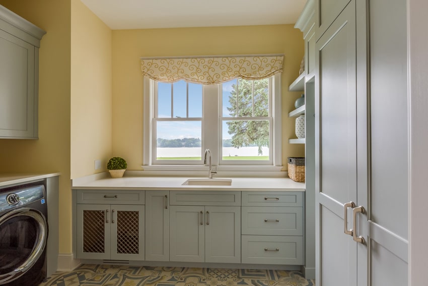 Vintage laundry room with curtains, washing machine, countertop, cabinets, and window