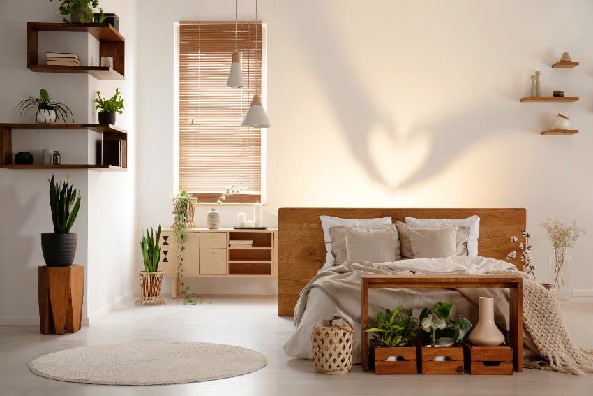 Warm bedroom interior with a bed table, wooden boxes, shadow on the wall and plants