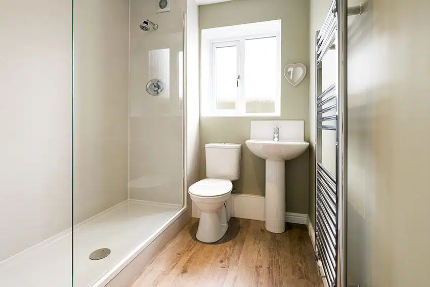 Bathroom frameless shower door and tower hanger with sink and pedestal
