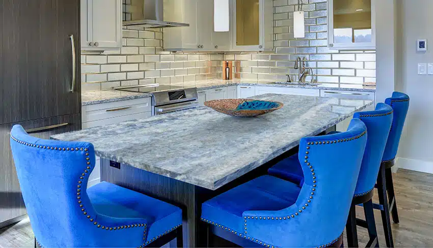 Kitchen with calcite kitchen island countertop upholstered stools glossy subway backsplash