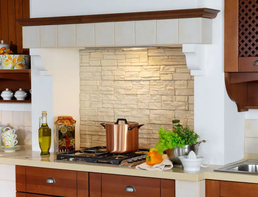 Tuscan kitchen with stacked stone backsplash, cabinets, countertop, and stove