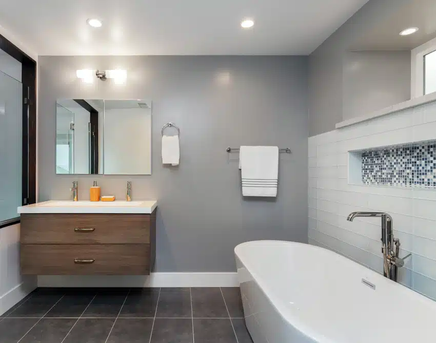 Bathroom with tub, tile floor, floating vanity, countertop, mirror ,towel holder, nickel bathtub faucet, window, and ceiling lights