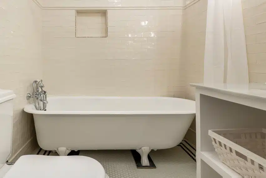 Bathroom with white tiles, tub, shower curtain, and armada clawfoot tub feet
