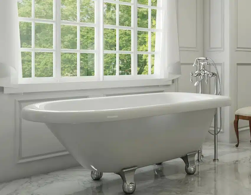 Bathroom with windows, tub, freestanding faucet, and cannonball clawfoot tub feet