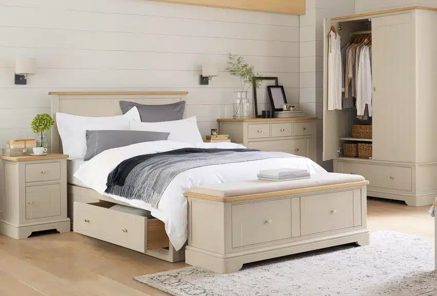 Bedroom with shiplap walls, grey pillows, headboard, and wood plank flooring