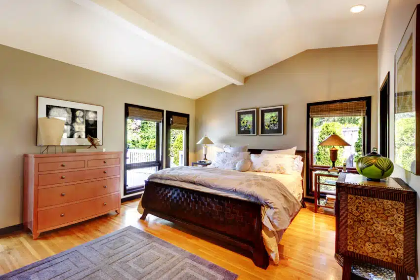 Bedroom with solid wood furniture, dresser, footboard, Venetian blinds and greige walls