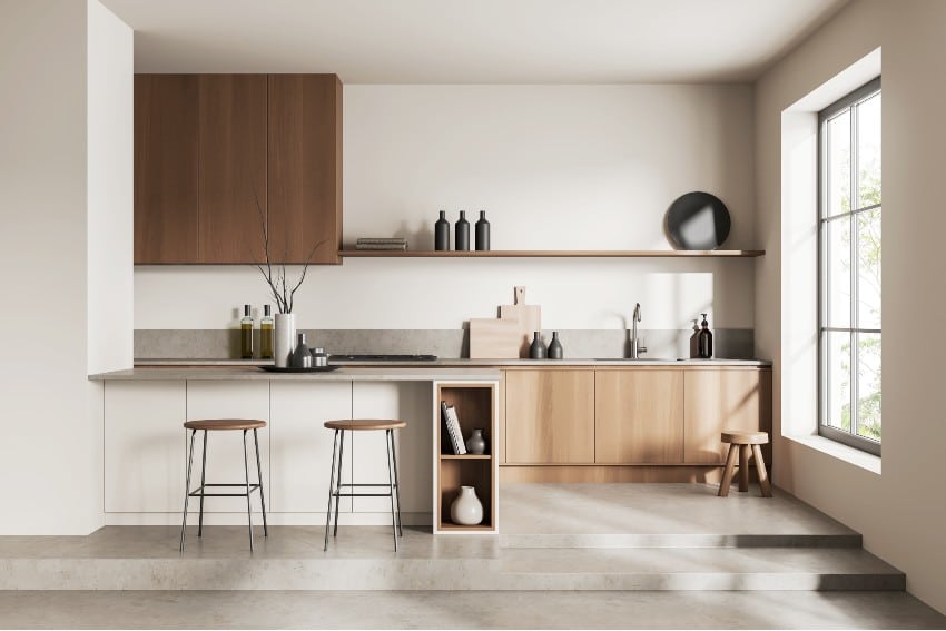 Beige kitchen with minimalist island, chairs on podium and grey concrete floor