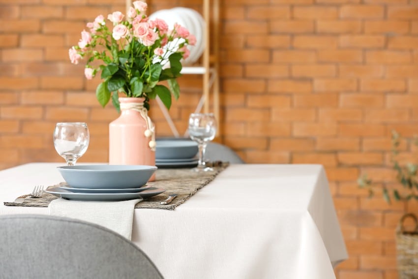 Bouquet of flowers on table with white cotton tablecloth in dining room