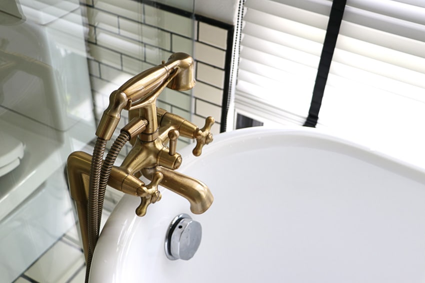 Brass bathtub faucet for bathrooms with tub and window blinds