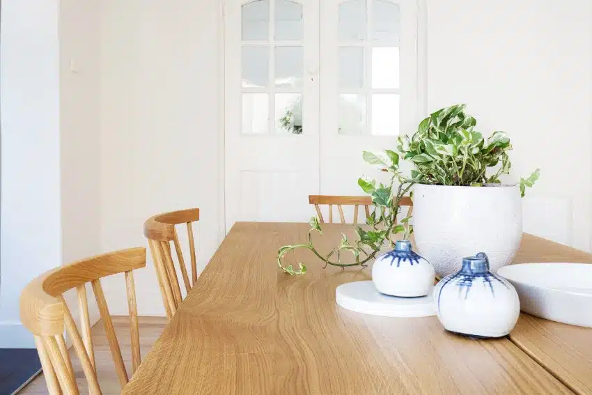 A close up details of scandi styled decor with chestnut wood furniture in contemporary dining room home interior