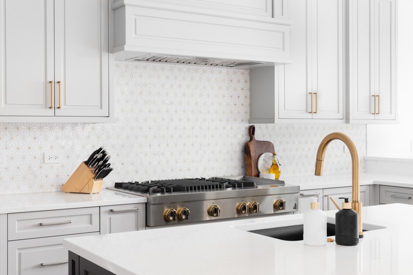 Flushed white kitchen with gold faucet