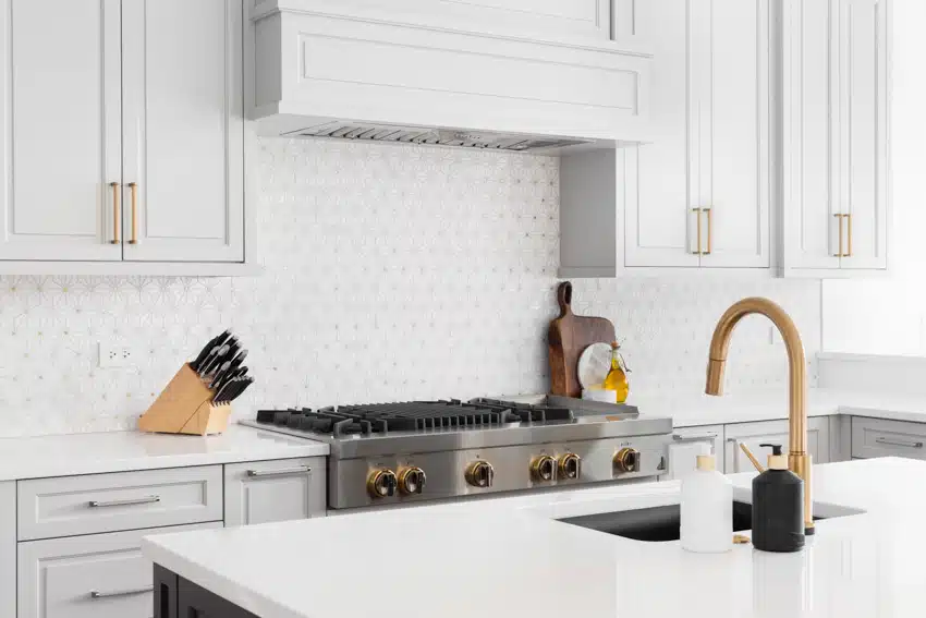 Flushed white kitchen with gold faucet