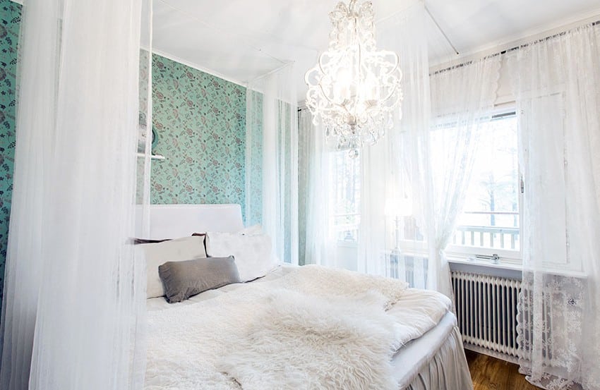 Glass chandelier, lace curtains, and blue green wallpaper