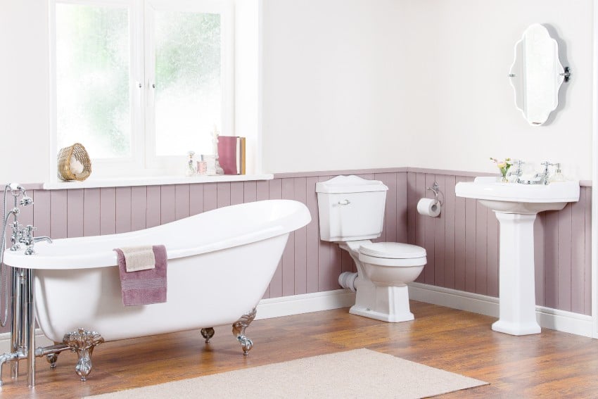 Elegant bathroom interior with luxury vintage bathtub, pedestal sink with a mirror and toilet