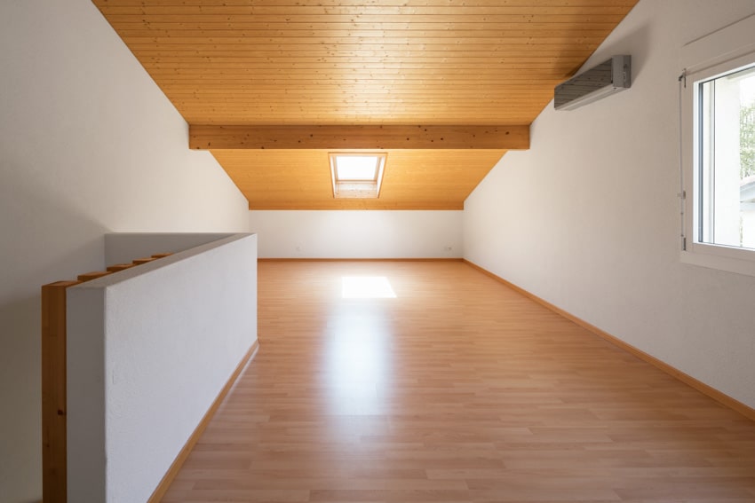 Empty attic with wood ceiling, white walls, hopper window, and finished wooden flooring