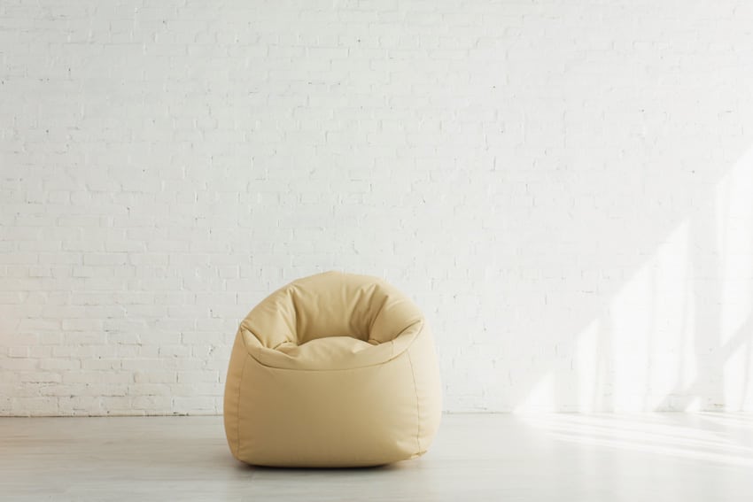 Empty room with small bean bag chair and white brick walls