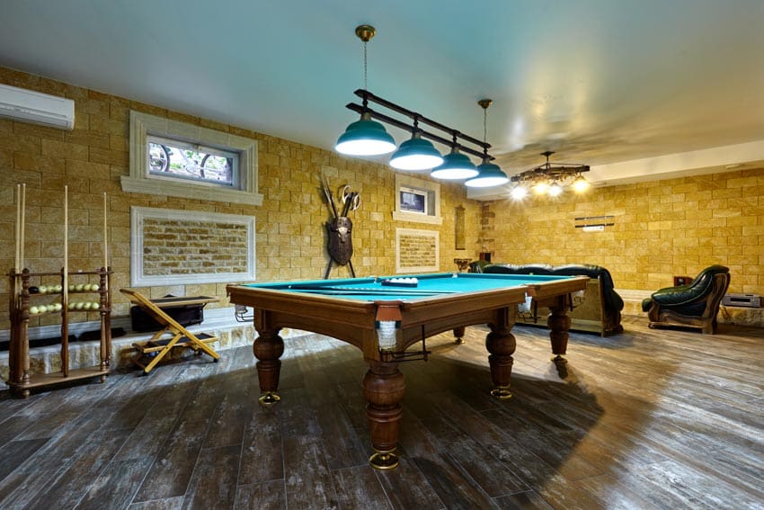 Game room with hopper window, billiards table, wood floor, brick wall, and pendant lights