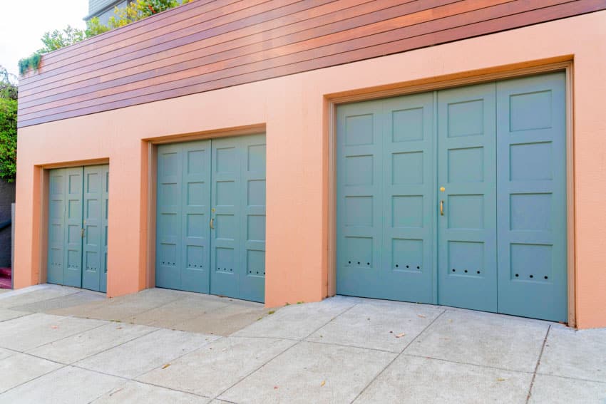 Garage with automatic doors, wood siding and driveway