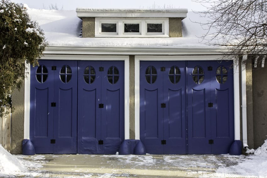 House exterior with blue bifold garage doors and driveway
