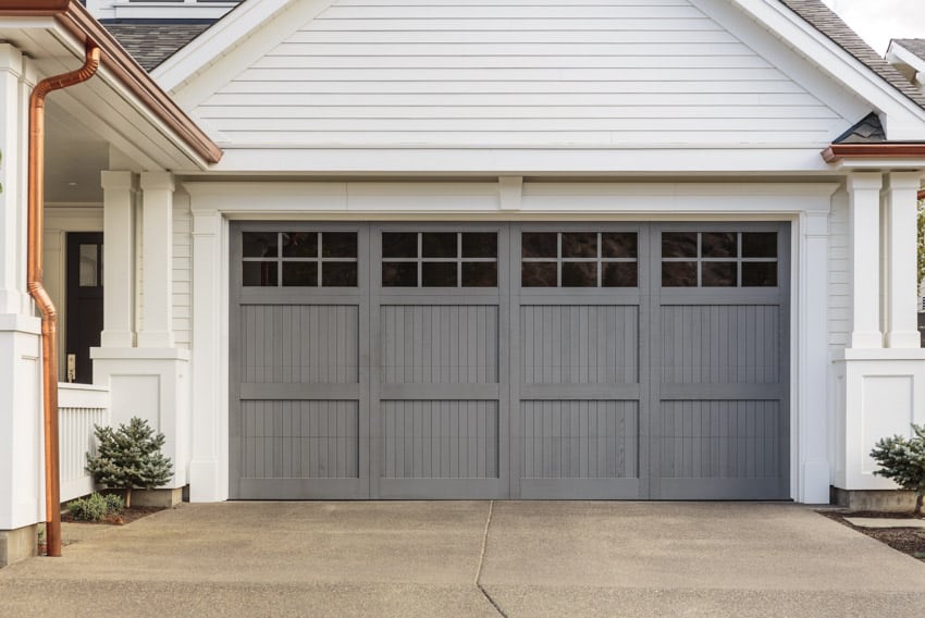 House with carriage doors, driveway and siding