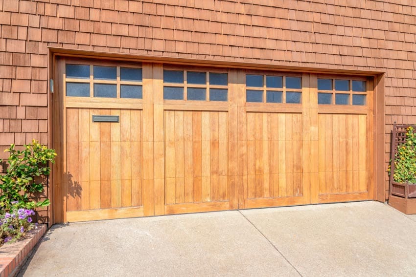 House with wall cladding, driveway, and bifold doors