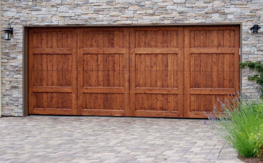 House with wooden bifold doors, driveway, and stone wall cladding