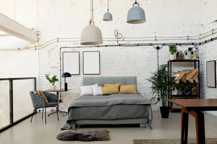 Industrial bedroom with furniture, chair, bed, pillows, pendant lights, shelves, and indoor plant
