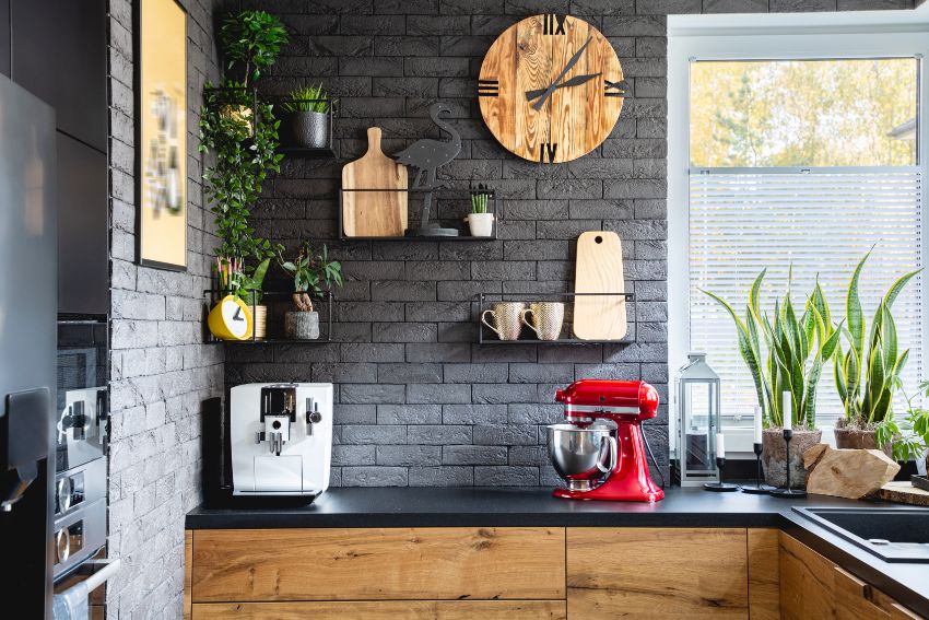 Kitchen features granite countetop with coffe machine and mixer, wood cabinets and black rustic subway tile backsplash