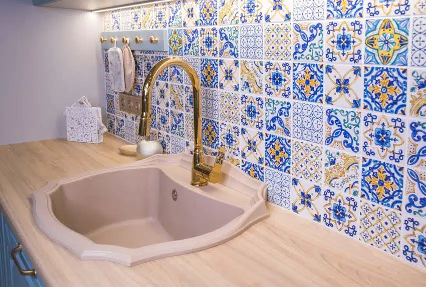 Kitchen with colorful intricate tile and gold faucet