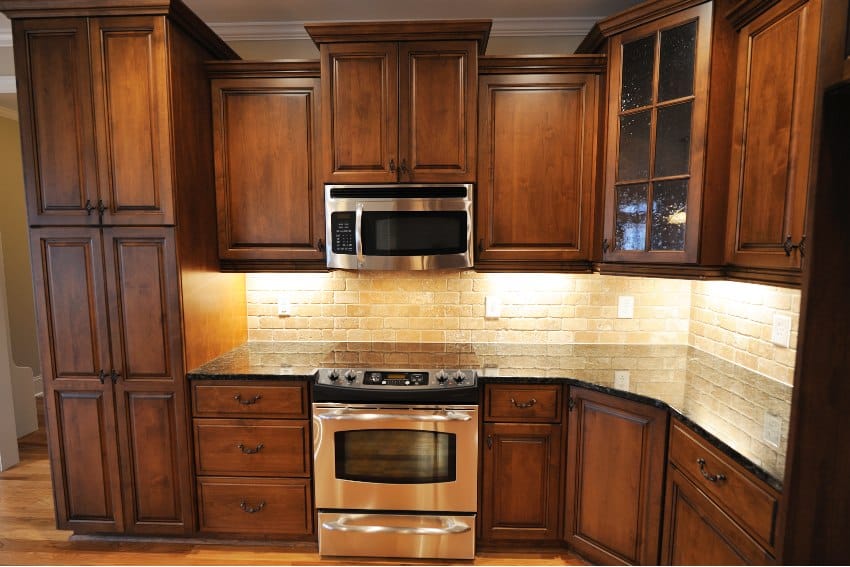 Kitchen with hardwood cabinets and rustic stone backsplash