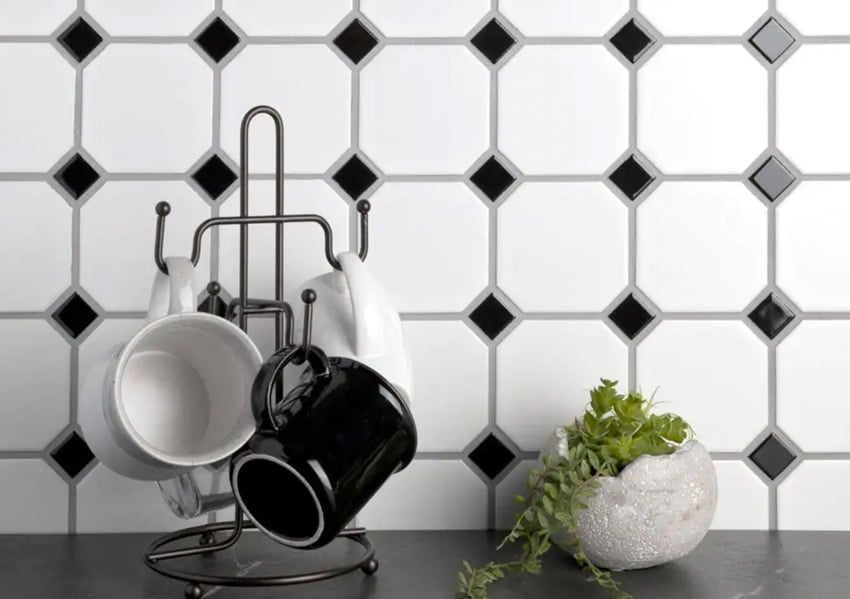 Kitchen with white and black backsplash and mugs on a rack