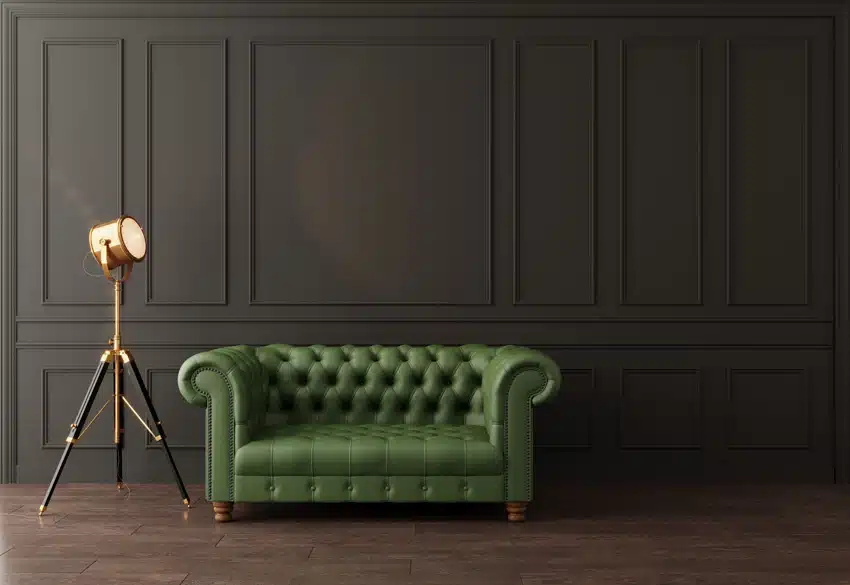 Couch in green leather set with metallic box lamp and dark matte walls